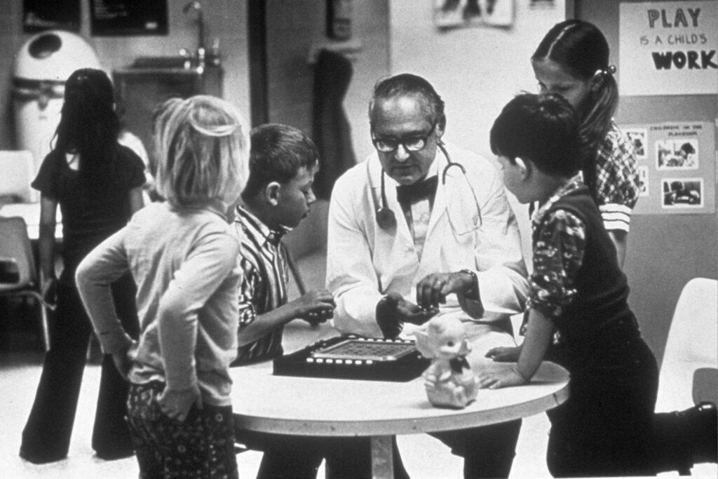 Dr. Kempe sitting with children